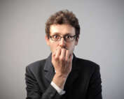 Man in suit and glasses with a scared look on his face