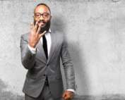 Man in suit and glasses holding up 4 fingers