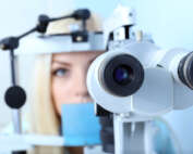 Woman peering through eye examination equipment